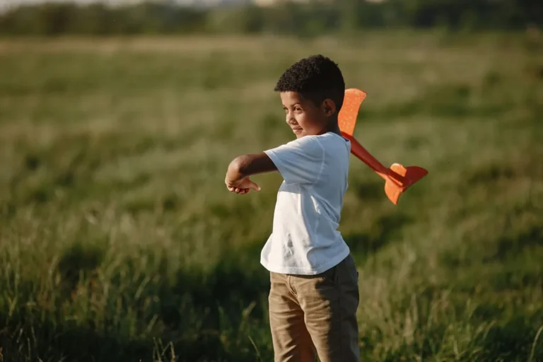 Niño jugando con un avión de juguete al aire libre