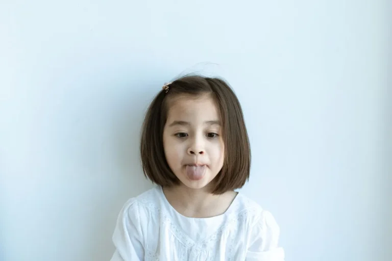 Niña sacando la lengua y poniendo una cara divertida