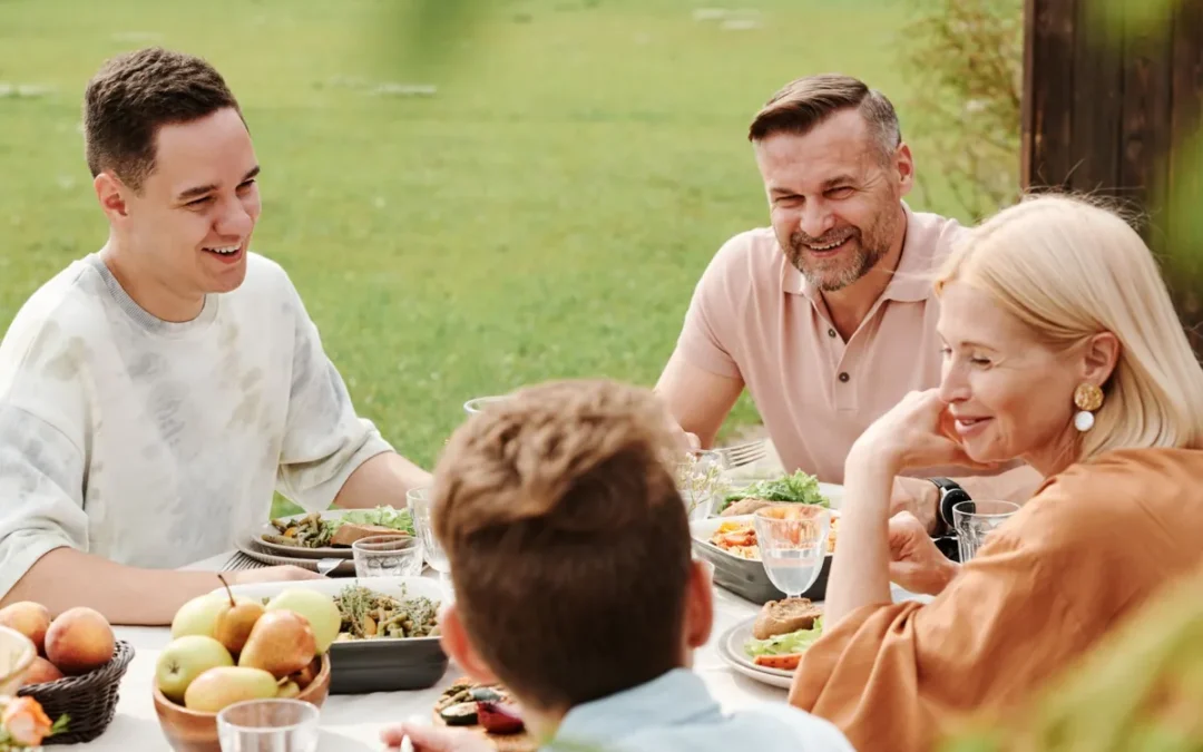 Familia riéndose a carcajadas alrededor de la mesa