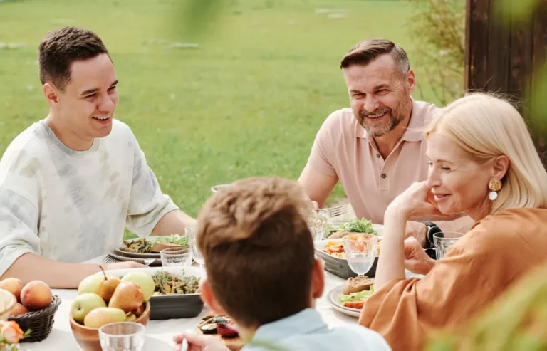Familia riéndose a carcajadas alrededor de la mesa
