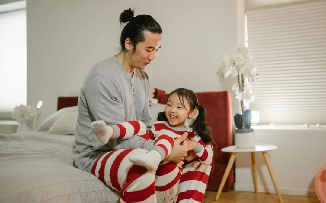 Padre e hija riéndose en casa después de contar un chiste malo